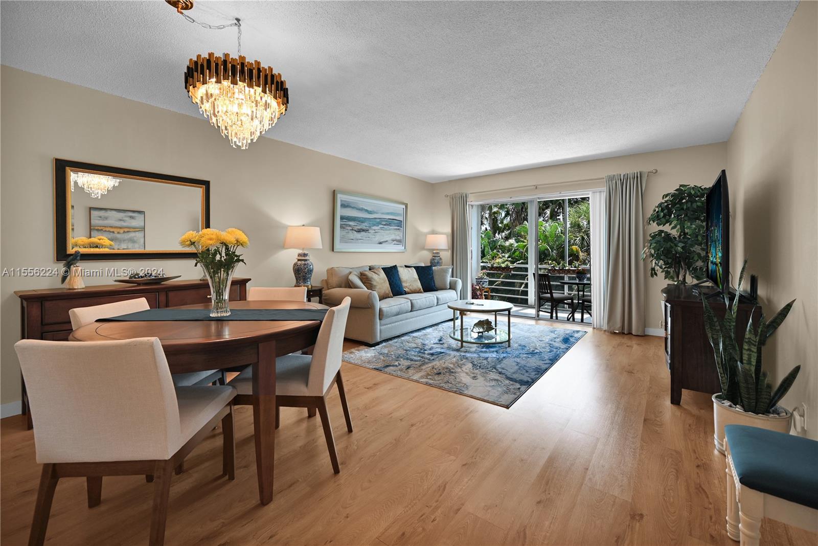 a living room with furniture a chandelier and a flat screen tv