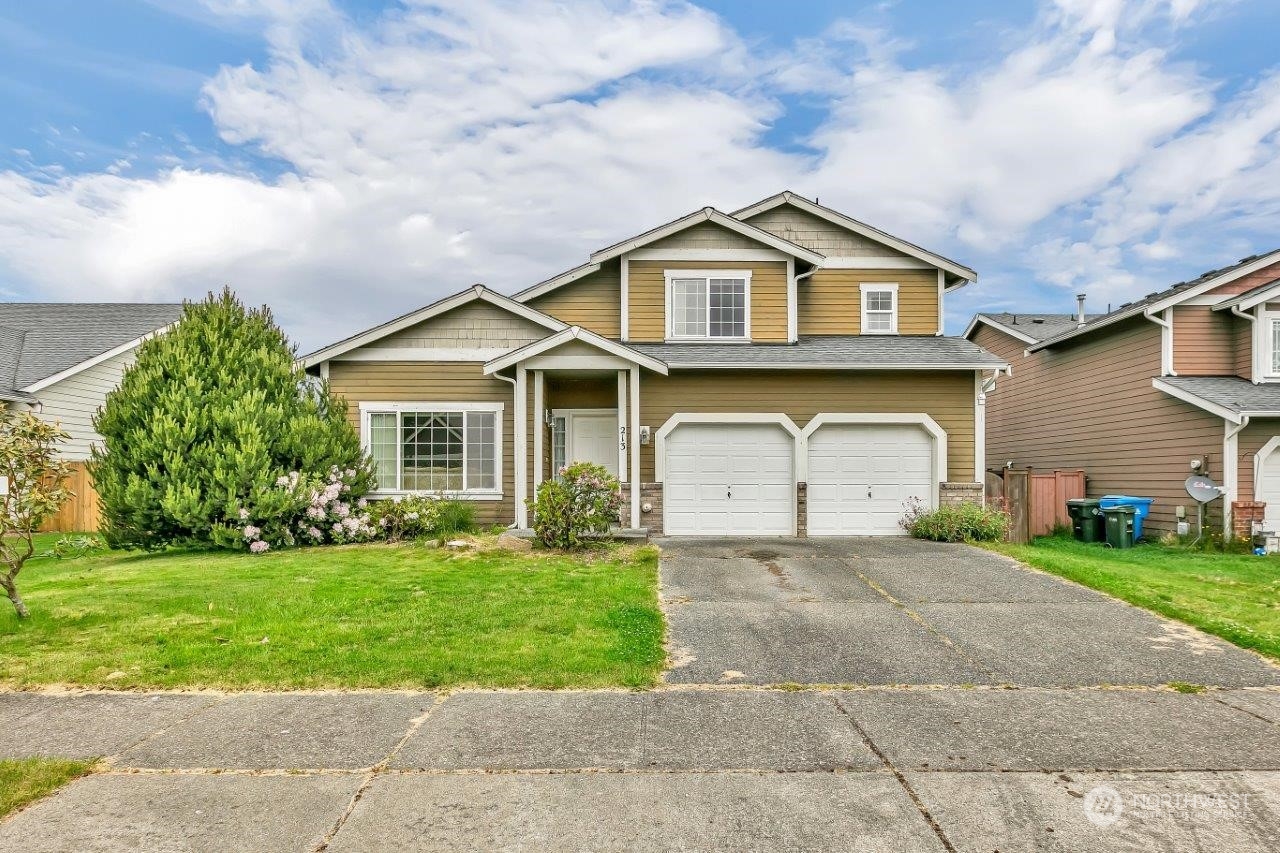 a front view of a house with a yard and garage