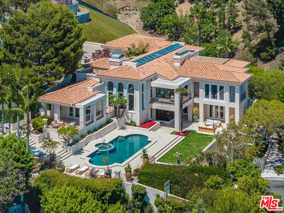 an aerial view of a house with swimming pool and garden