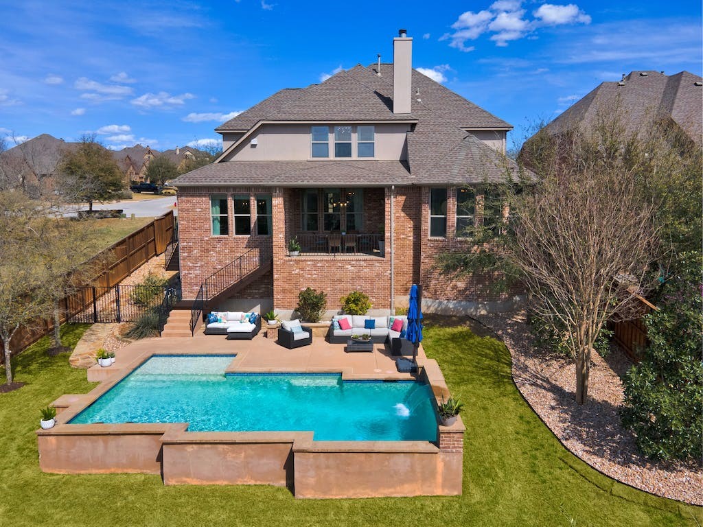 an aerial view of a house with garden space and sitting area