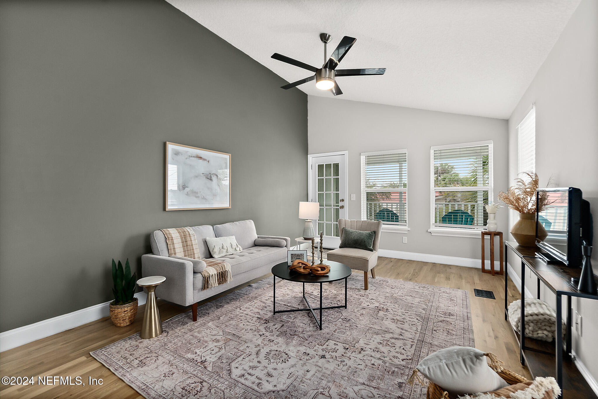 a living room with furniture a window and a flat screen tv