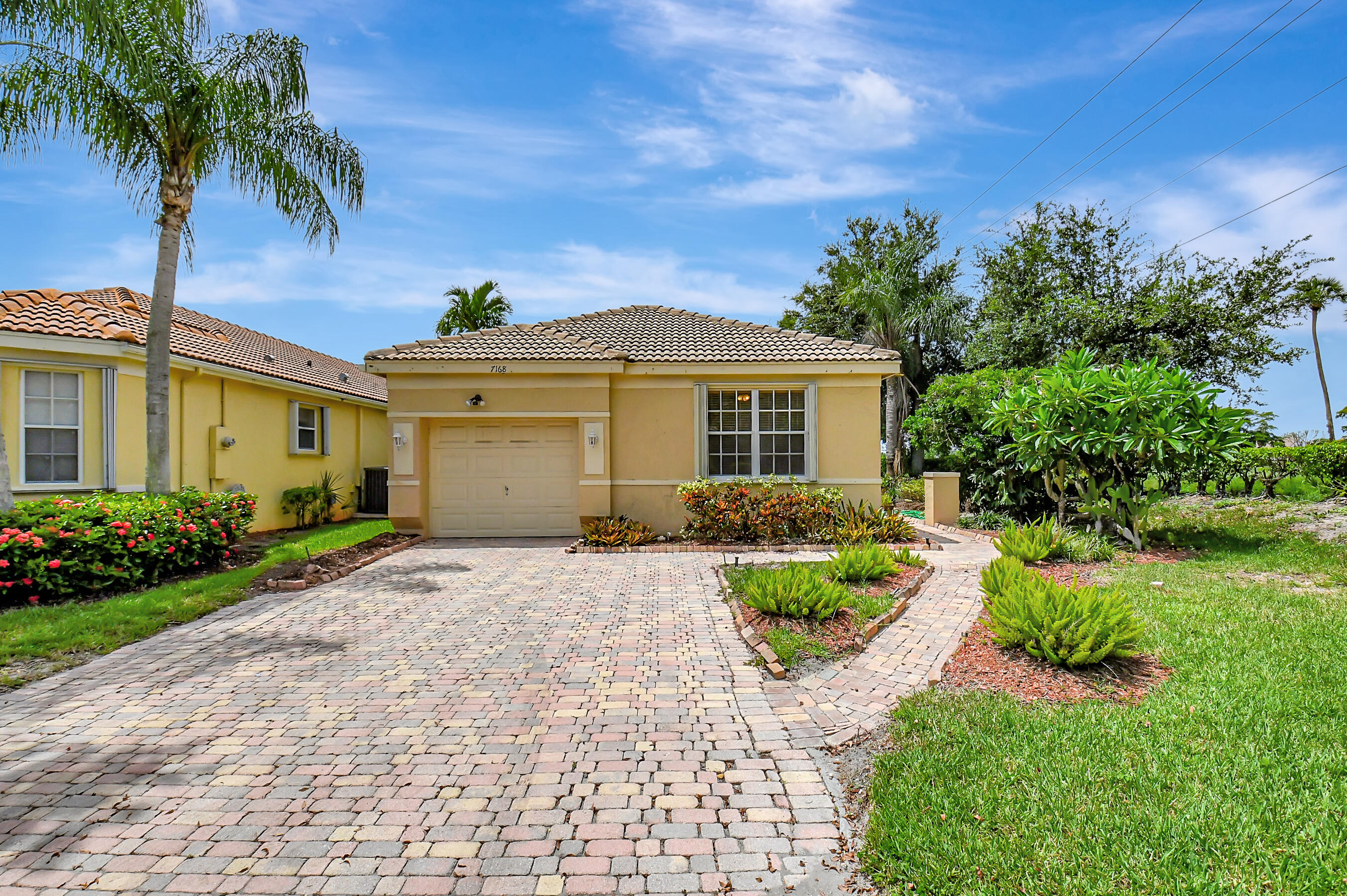 a front view of a house with a yard and potted plants