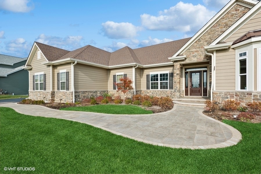 a front view of a house with a garden and yard