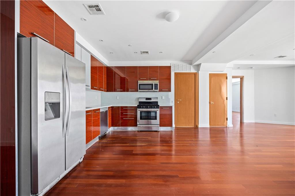 a view of kitchen with stainless steel appliances granite countertop a refrigerator and a stove top oven