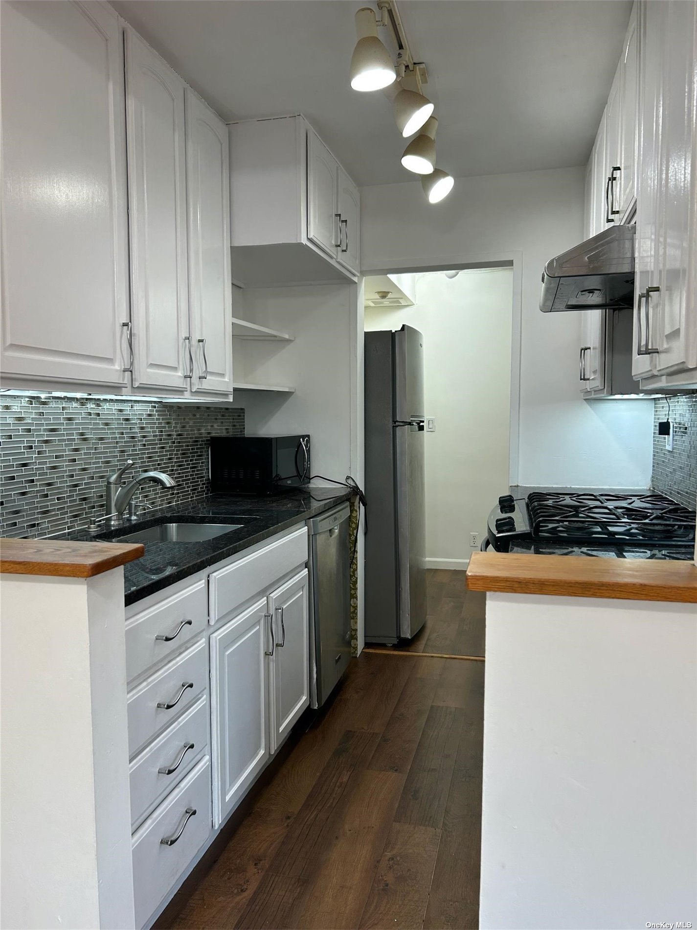 a kitchen with stainless steel appliances granite countertop a stove a sink and a refrigerator