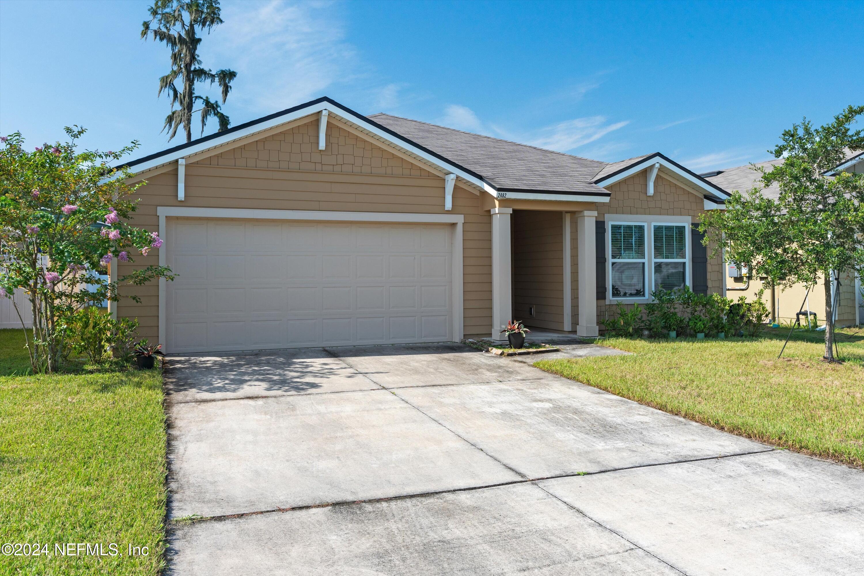 a front view of a house with a yard and garage