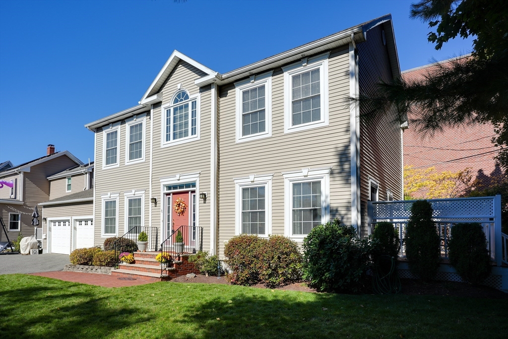 a front view of a house with a garden and plants