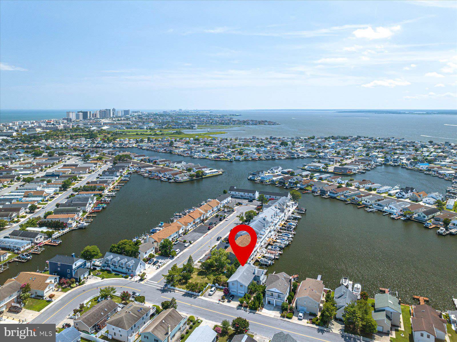 an aerial view of ocean and residential houses with outdoor space