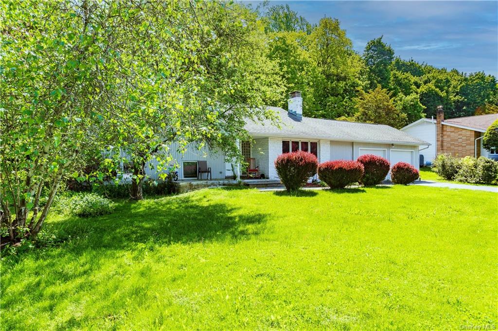 a front view of house with yard and green space