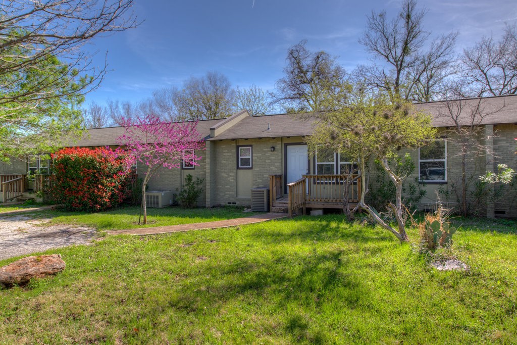 a view of a house with a yard and pathway