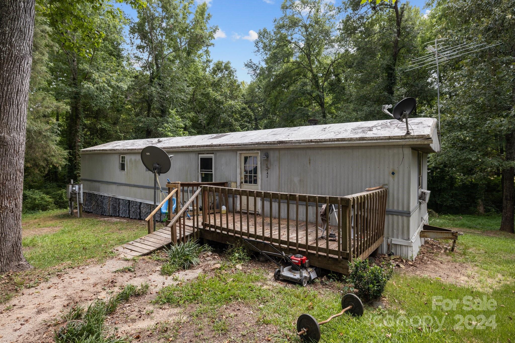 a view of a small house with yard and sitting area