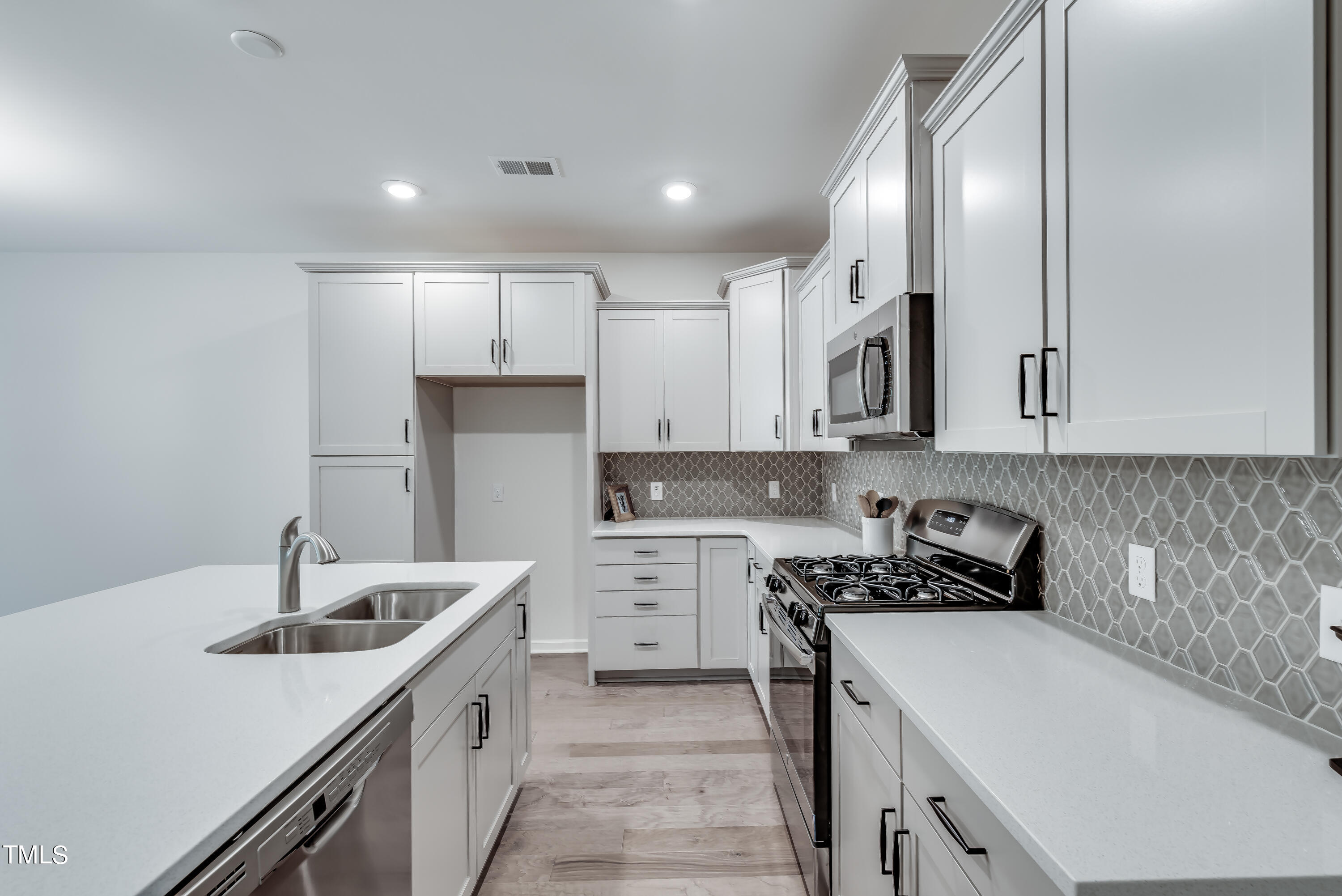 a kitchen with a sink stove top oven and refrigerator