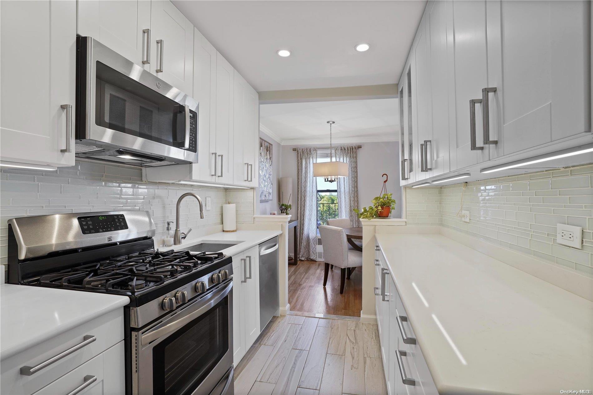 a kitchen with stainless steel appliances granite countertop a stove a sink and a microwave