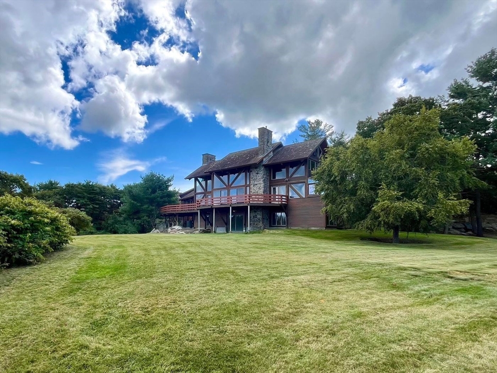 a view of a house with a big yard and a large tree