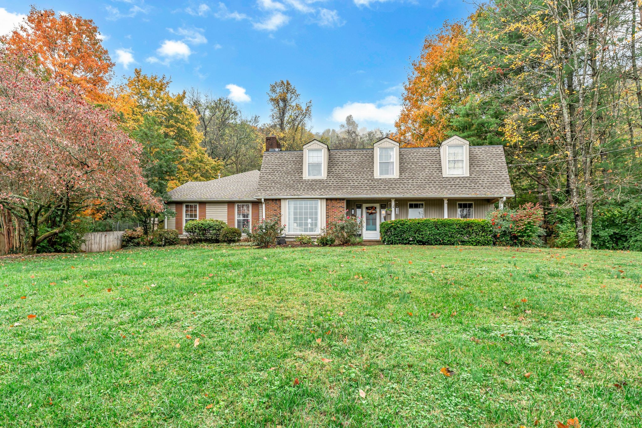 a front view of a house with a yard and trees