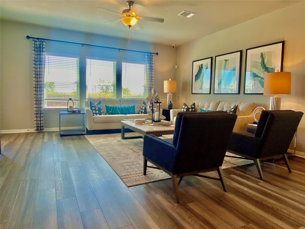 a living room with furniture and a wooden floor