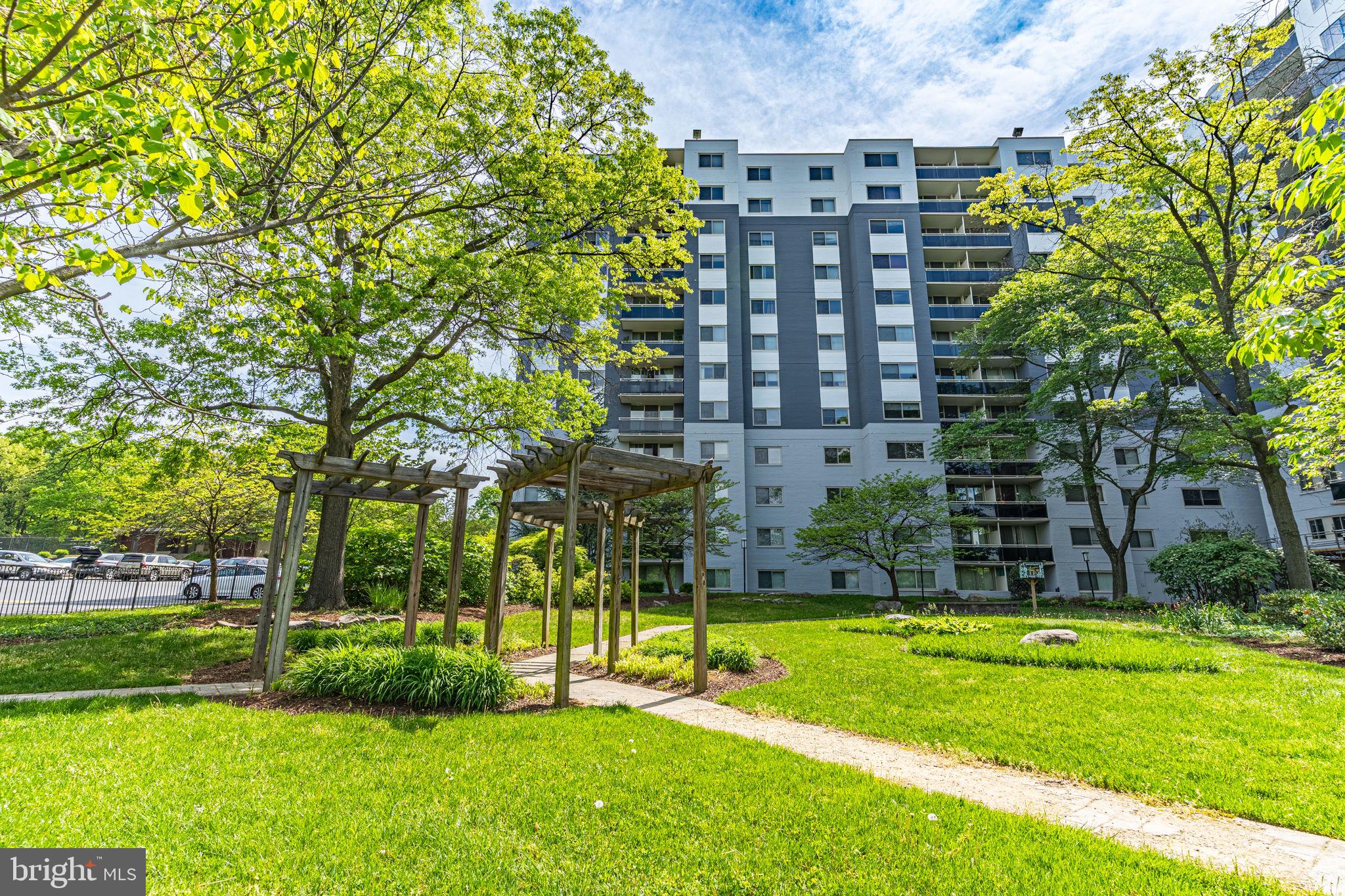 a view of building with a big yard and large trees