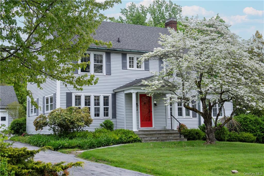 a front view of a house with a yard and trees