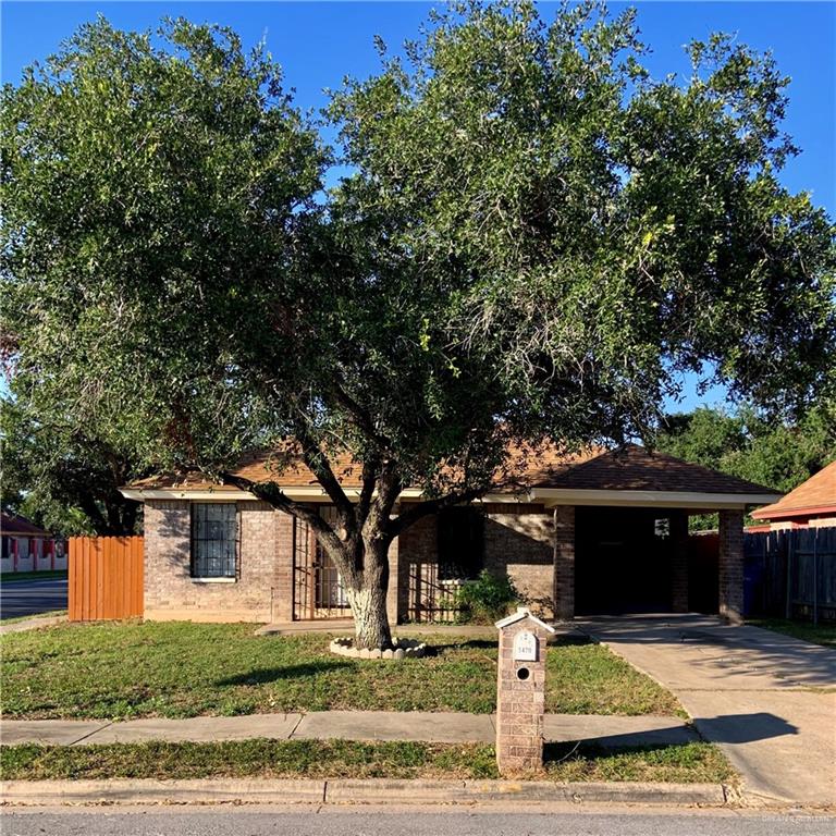 View of front of property featuring a front lawn and a carport