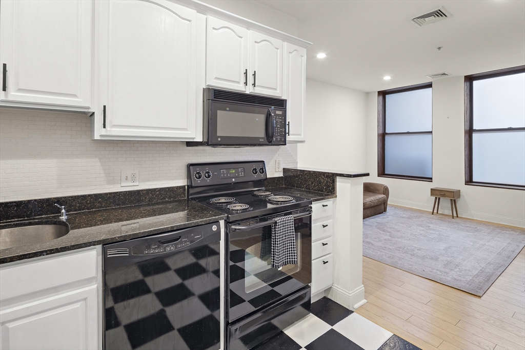 a kitchen with stainless steel appliances granite countertop a sink stove and cabinets