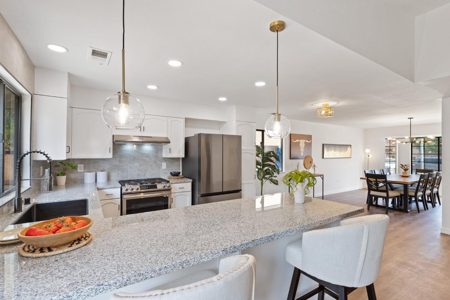 a kitchen with stainless steel appliances granite countertop sink stove and refrigerator