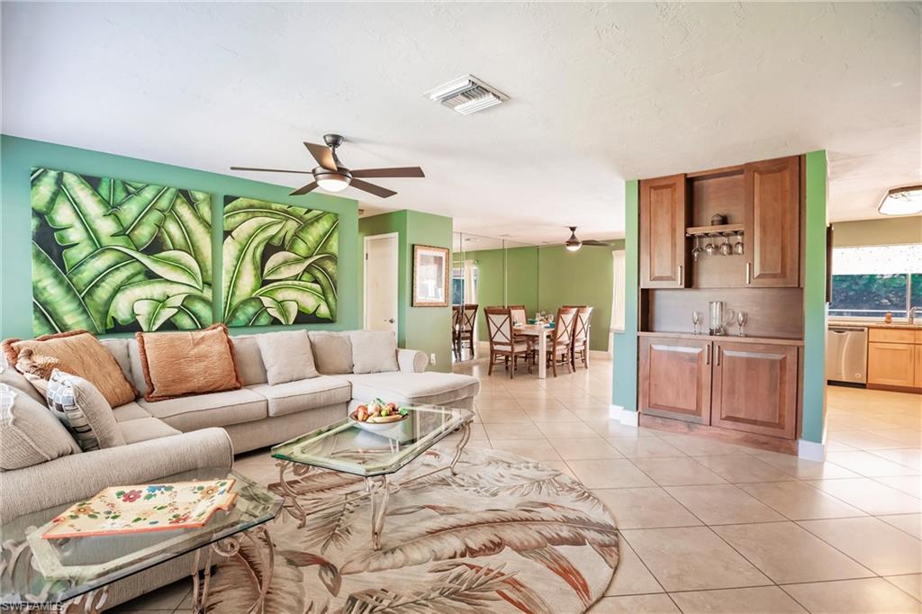 a living room with furniture kitchen view and a large window