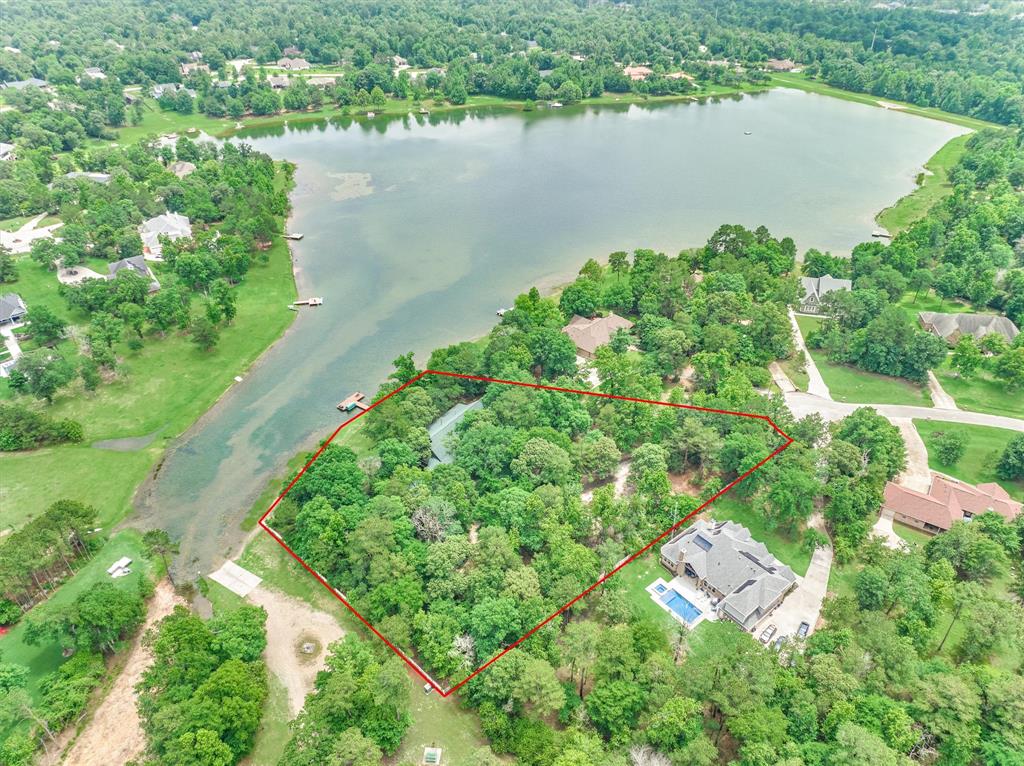 an aerial view of residential houses with outdoor space and lake view