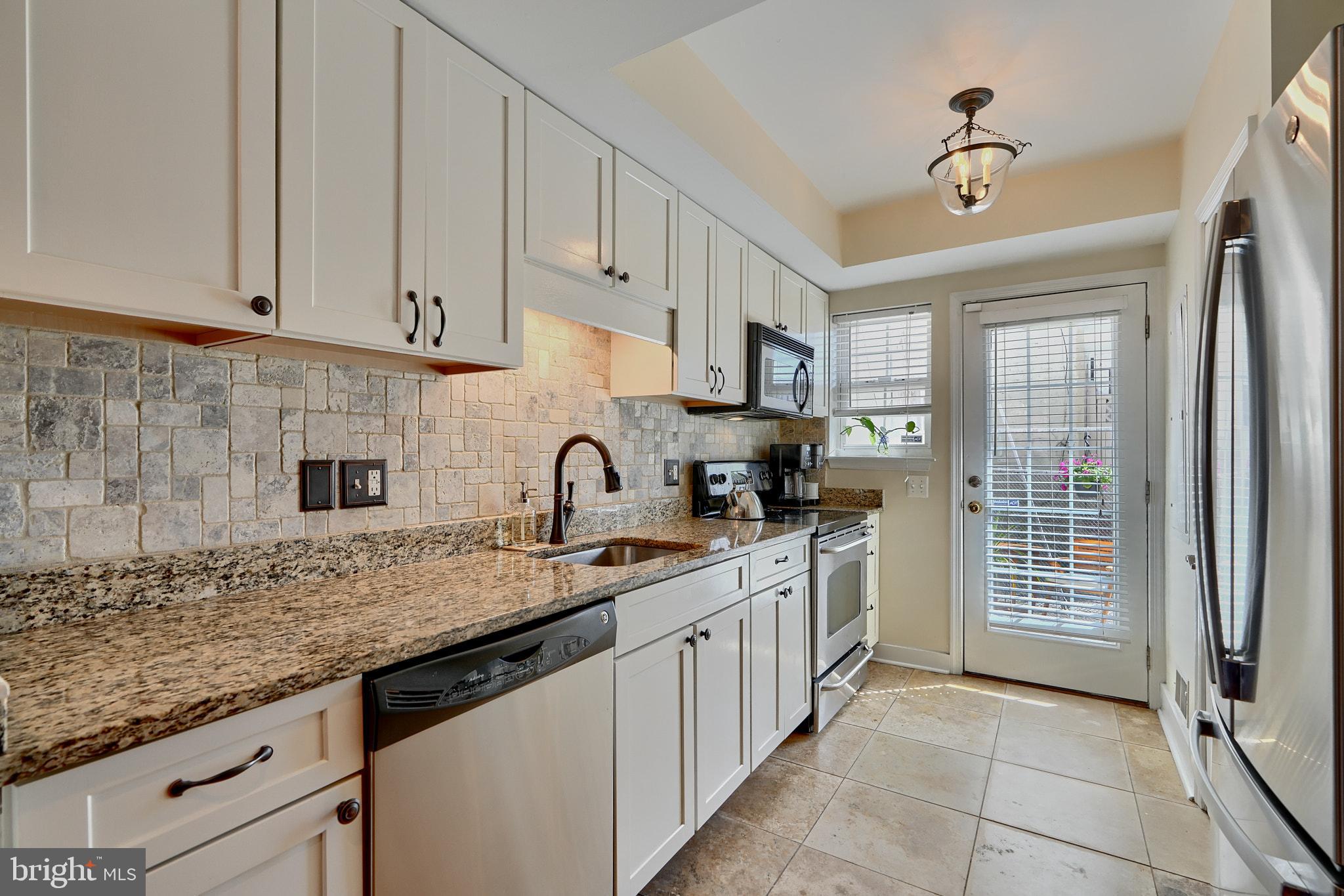 a kitchen with stainless steel appliances granite countertop a sink stove and cabinets