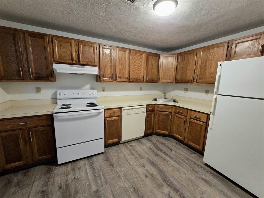 a kitchen with wooden cabinets and white appliances