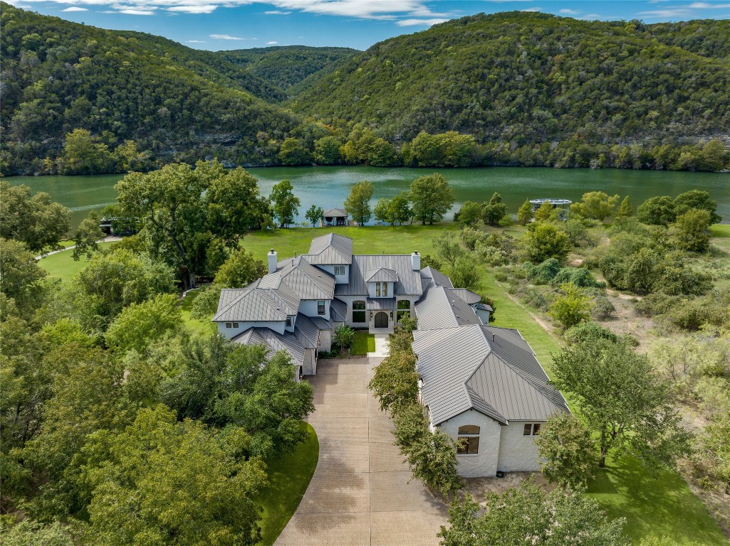 an aerial view of a house with garden space and a lake view