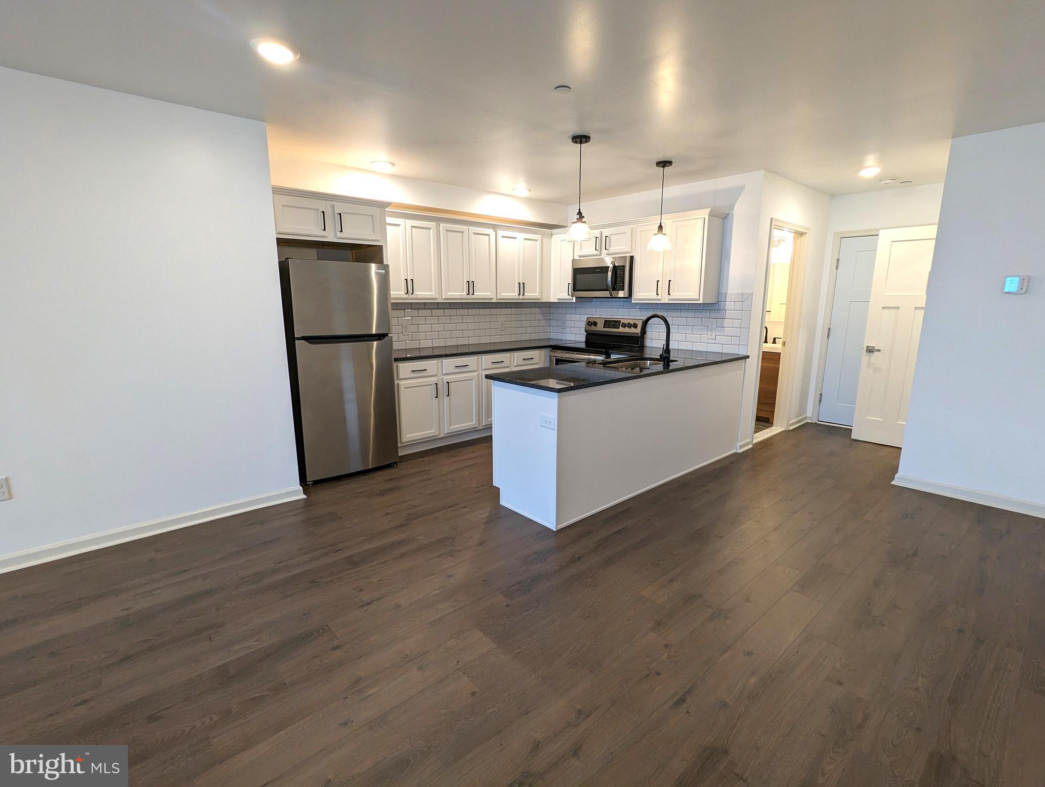 a large kitchen with a refrigerator a sink and a stove