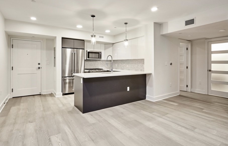 a kitchen with stainless steel appliances kitchen island granite countertop a refrigerator and a sink