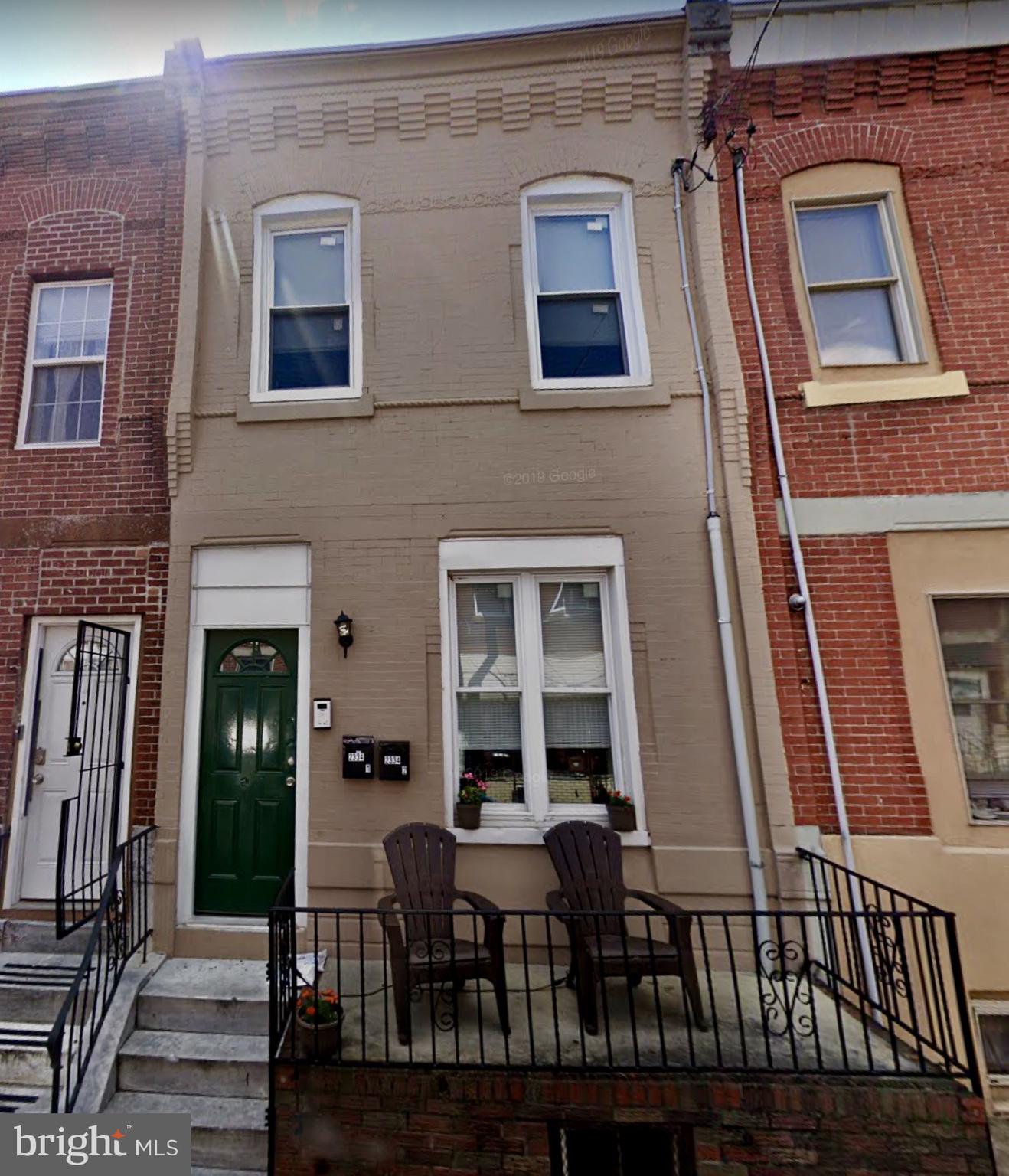 a view of a brick house with large windows and a table