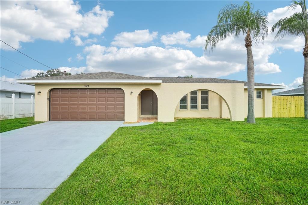 View of front of home with a garage and a front yard