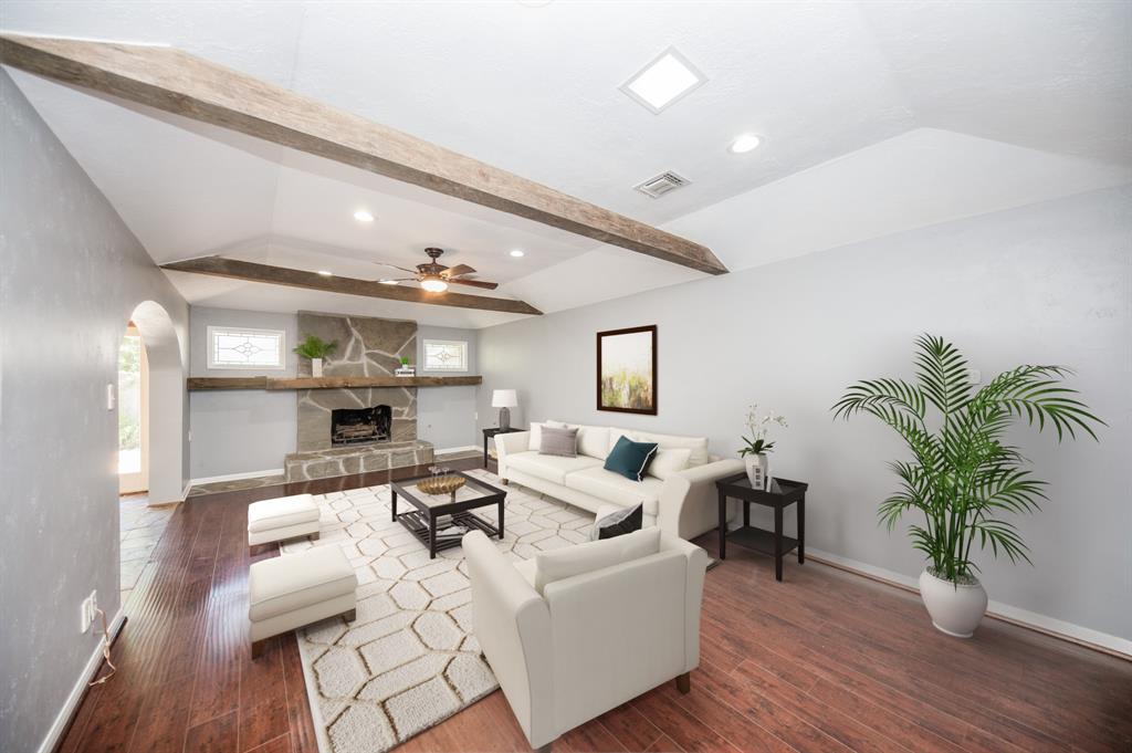 a living room with furniture kitchen view and a potted plant