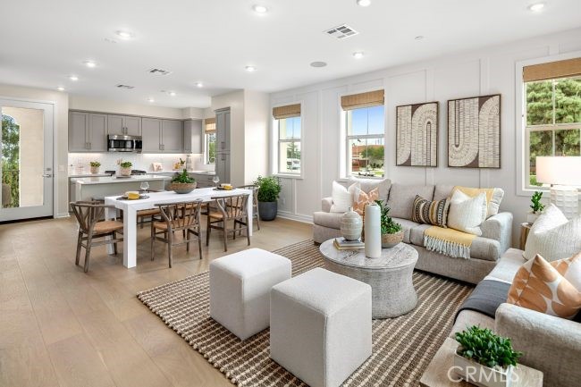 a living room with furniture and a dining table with wooden floor