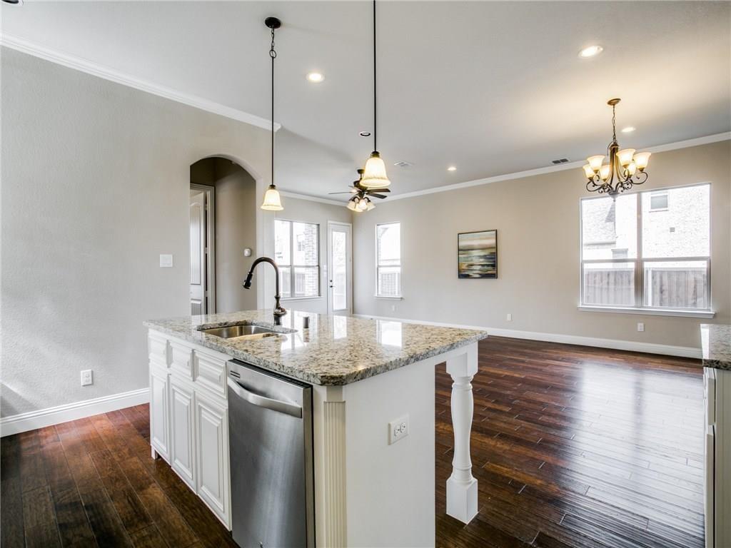 a kitchen with stainless steel appliances granite countertop a sink a stove and a wooden floors