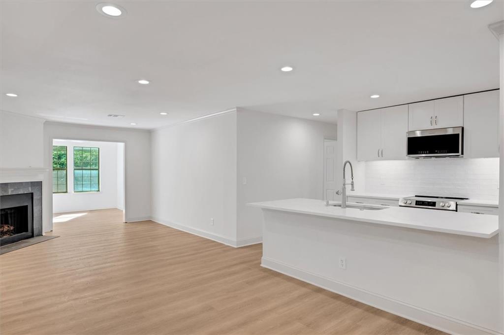 a view of kitchen with sink wooden floor and window