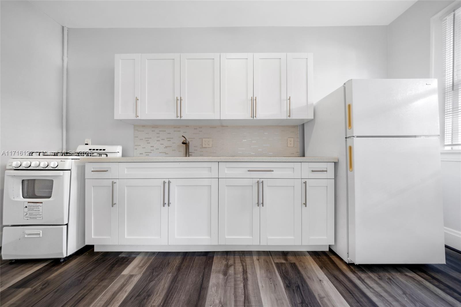 a kitchen with white cabinets and white appliances