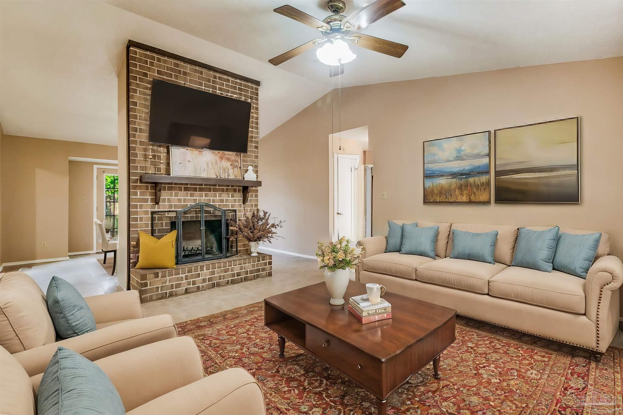 a living room with furniture a flat screen tv and a fireplace