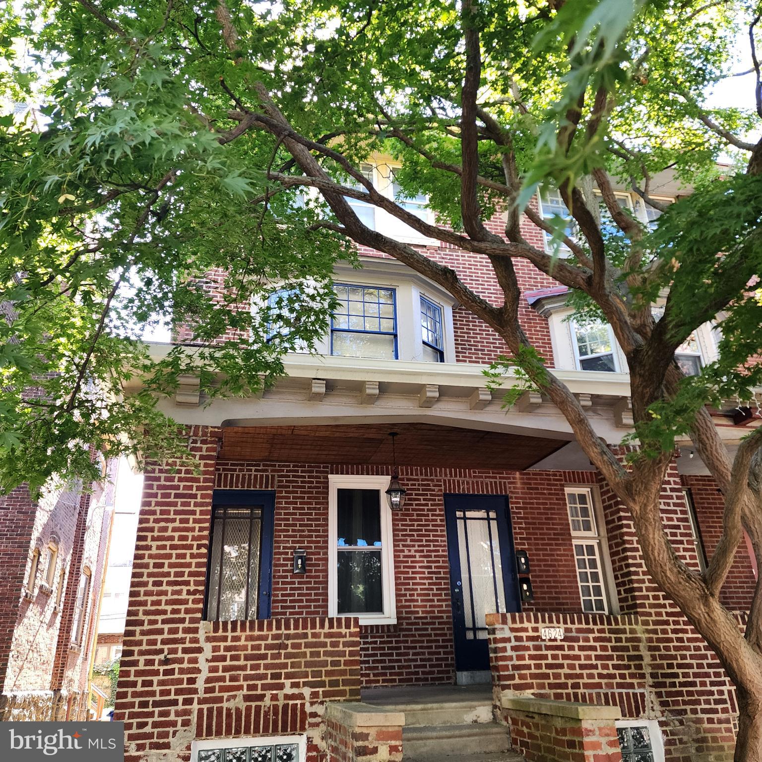 a front view of a house with a tree