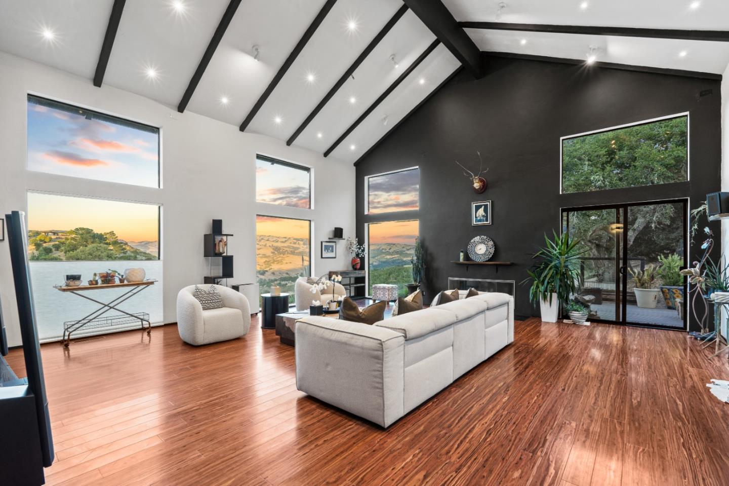 a living room with furniture floor to ceiling window and wooden floor