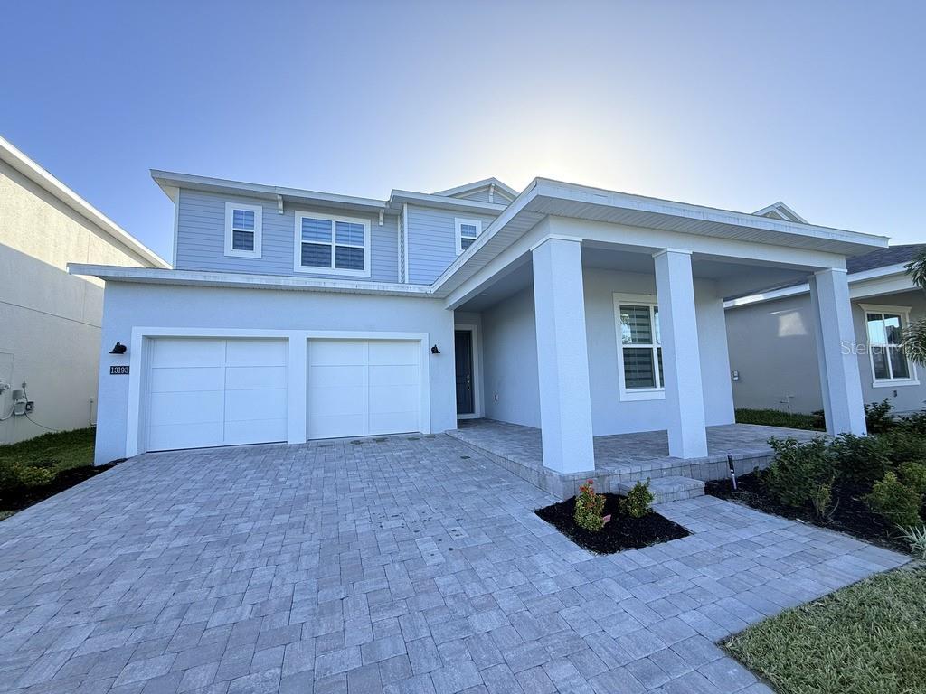 a view of a house with porch and a yard