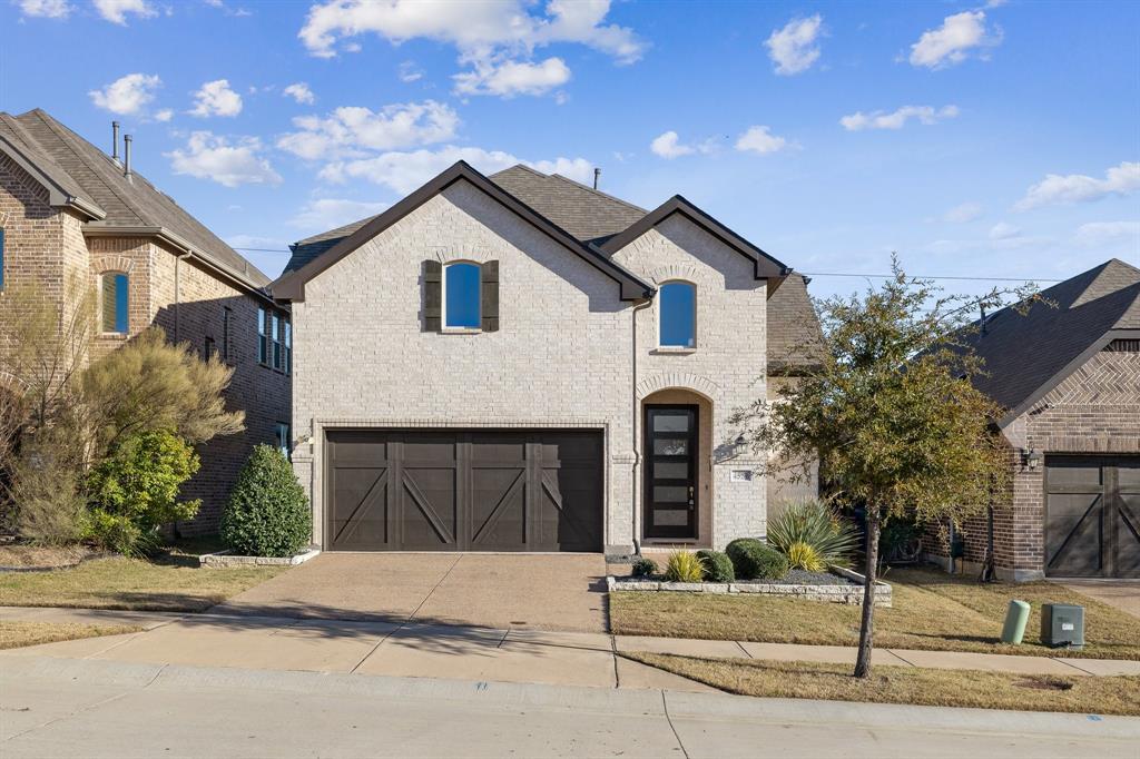 a front view of a house with garage and parking