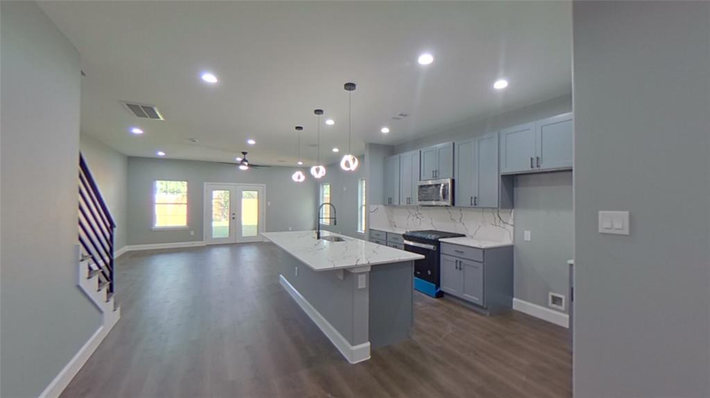 a kitchen with stainless steel appliances granite countertop a sink stove and refrigerator