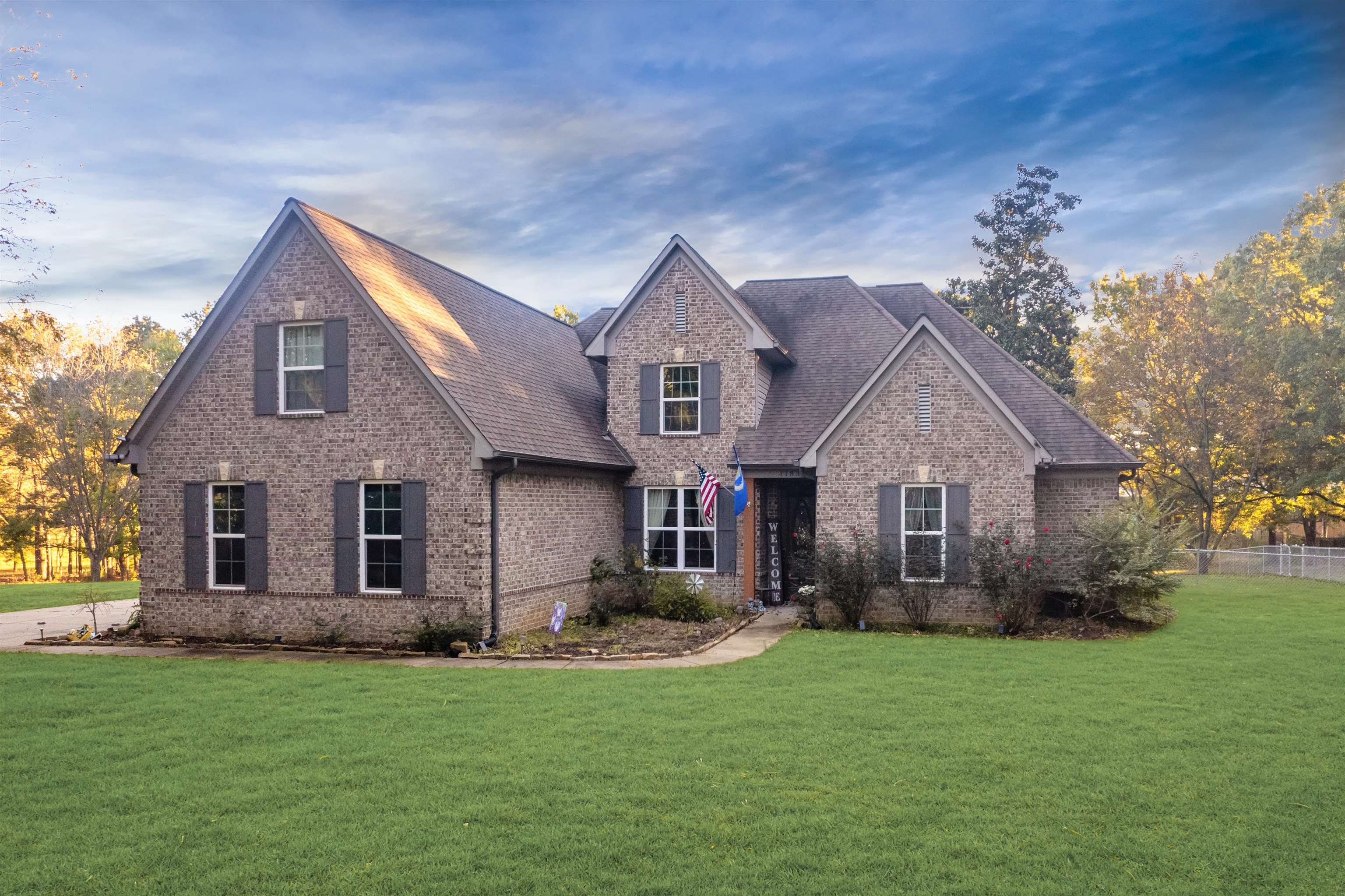 a front view of house with yard and green space