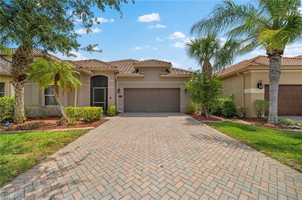 front view of a house with a yard and palm trees