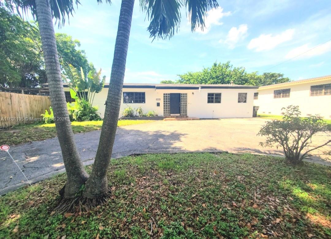 a view of a house with backyard and a tree