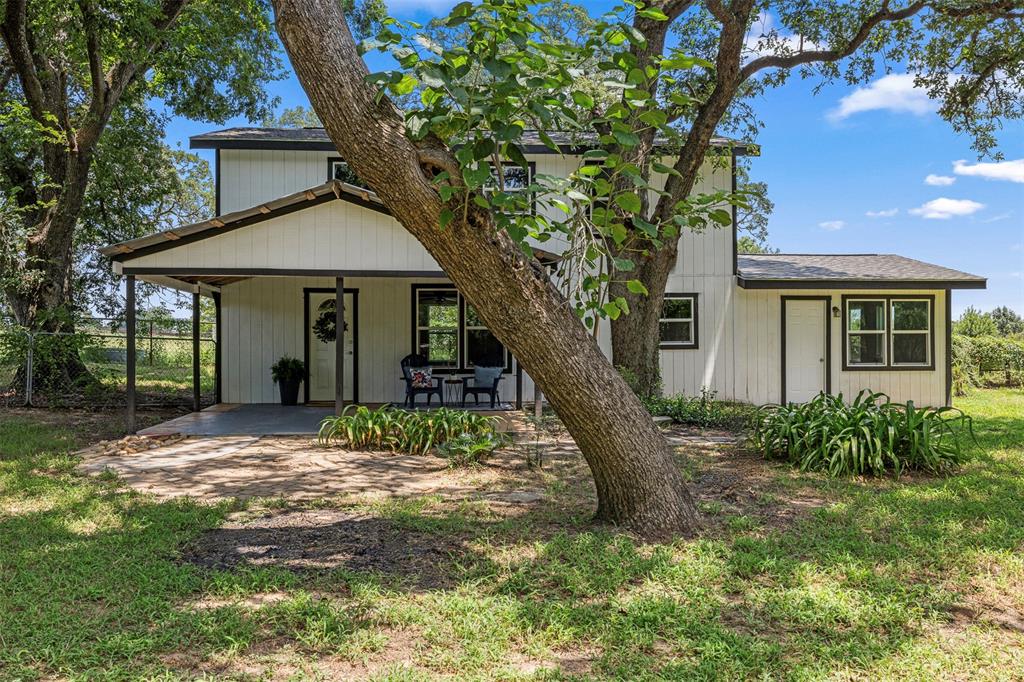 a view of a house with a tree in the yard