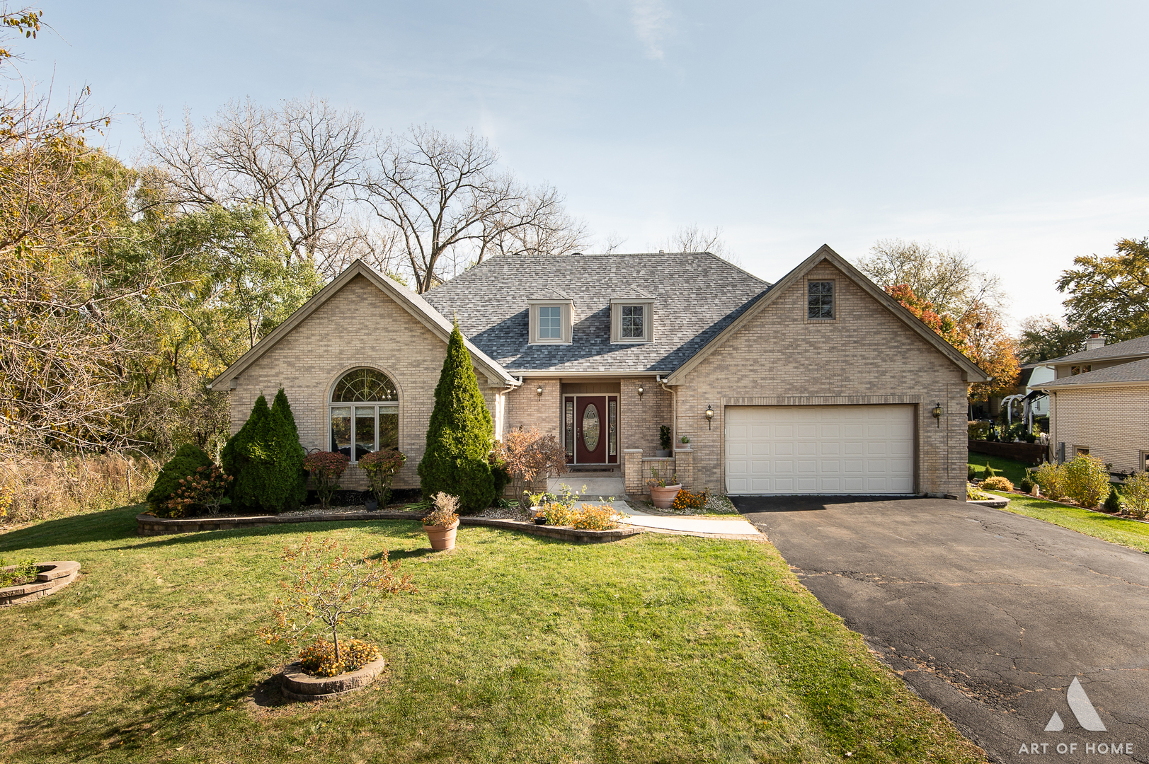 a front view of house with yard and trees in the background